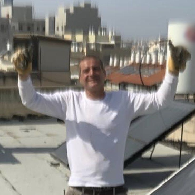 שרון על גג שטוח, מלחים יריעת איטום עם מבער ביד אחת וכף בנייה ביד השנייה